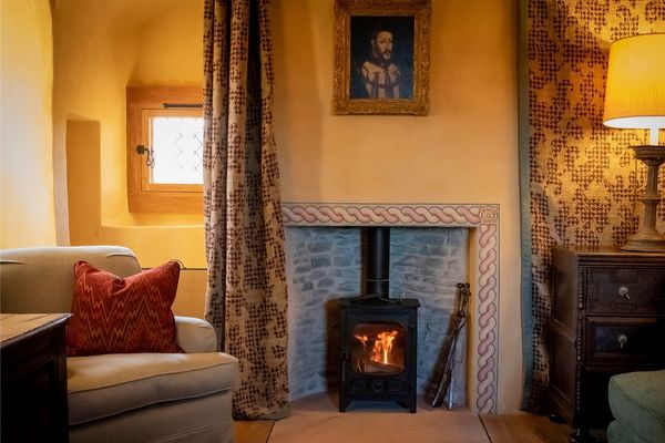 Interior of Fairburn with a fireplace, sofas and curtains