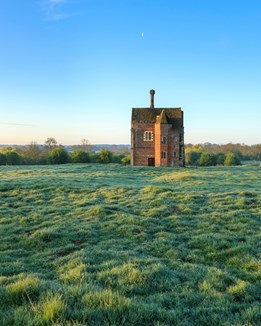 A medieval abbey building surrounded by fields