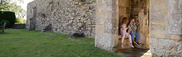 Children sitting in an archway at Woodspring Priory