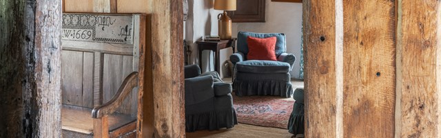 A view through a wooden passage to a sitting room