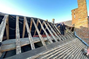 A timber frame roof being repaired