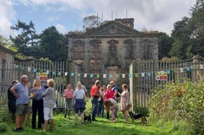 A group of people standing outside a derelict building